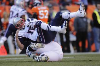 New England Patriots quarterback Tom Brady (12) is sacked by Denver Broncos defensive end Robert Ayers (91) during the second half of the AFC Championship NFL playoff football game in Denver, Sunday, Jan. 19, 2014. (AP Photo/Joe Mahoney)